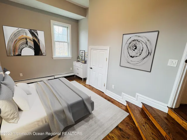 a bedroom with a bed and painting on the wall