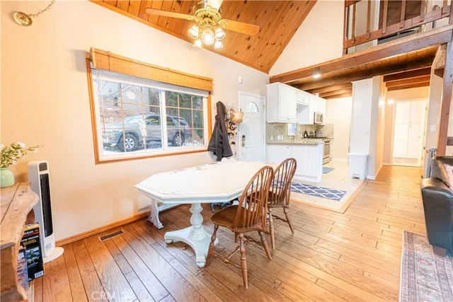 a dining room with furniture a chandelier and wooden floor
