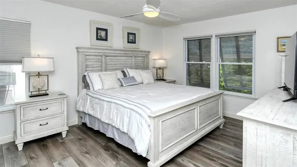 a bed sitting in a spacious bedroom next to a window
