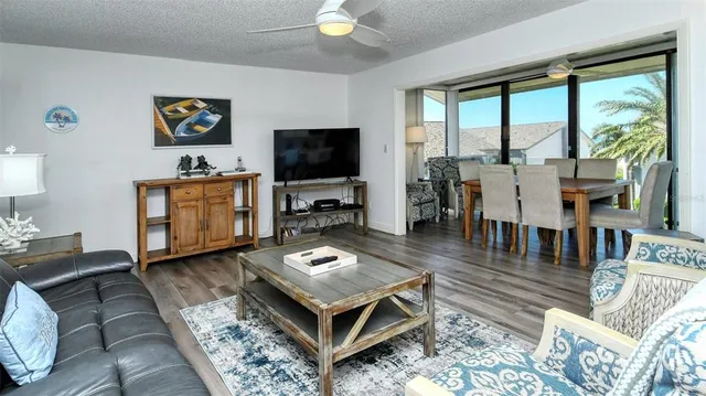 a living room with furniture a flat screen tv and a large window