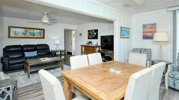 a living room with furniture a flat screen tv and kitchen view
