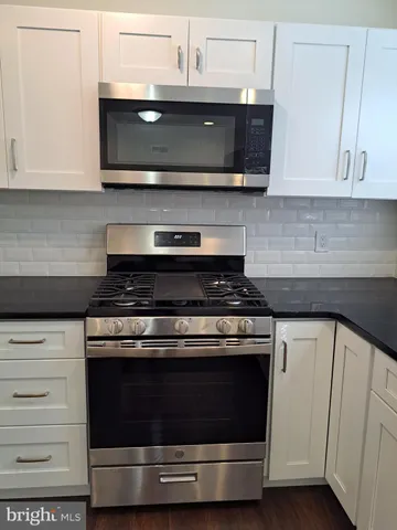 a kitchen with stainless steel appliances granite countertop a stove and a microwave