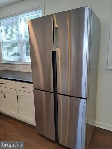 a metallic refrigerator freezer sitting in a kitchen