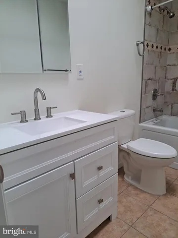 a bathroom with a granite countertop toilet sink and mirror