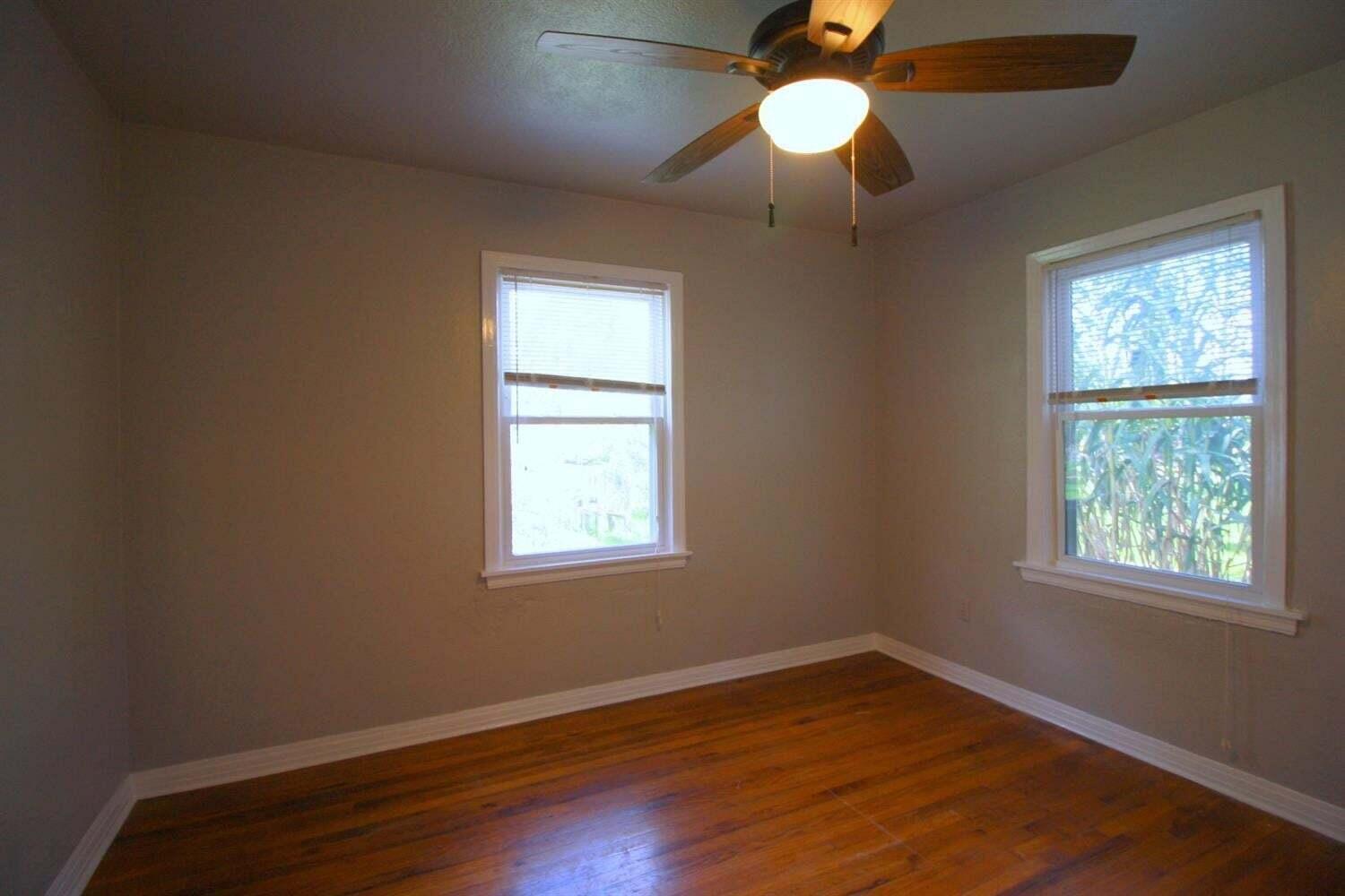 2611 28th Street Lubbock, TX 79410 - Photo 15 of 22 a view of an empty room with wooden floor and a window