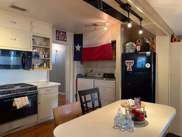 a kitchen with stainless steel appliances granite countertop a stove refrigerator and a dining table with wooden floor