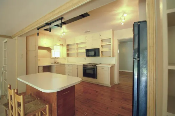 a kitchen with a sink stainless steel appliances and white cabinets