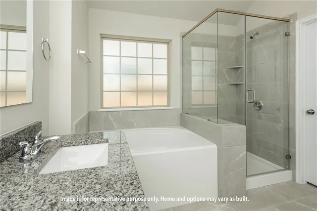 a bathroom with a granite countertop tub a sink and a shower