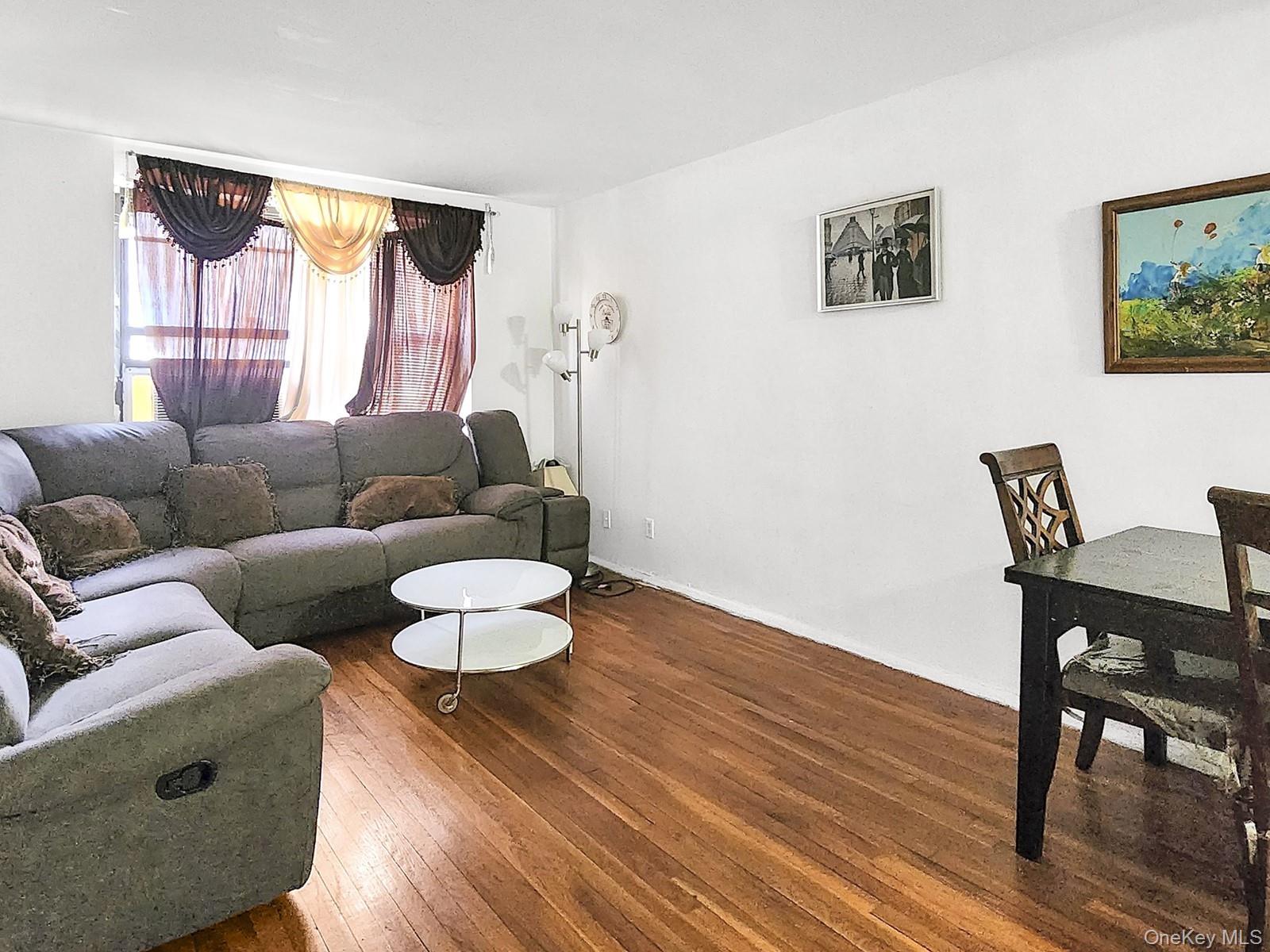 139-15 28th Road, Unit 1F Queens, NY 11354 - Photo 2 of 6 a living room with furniture and a wooden floor