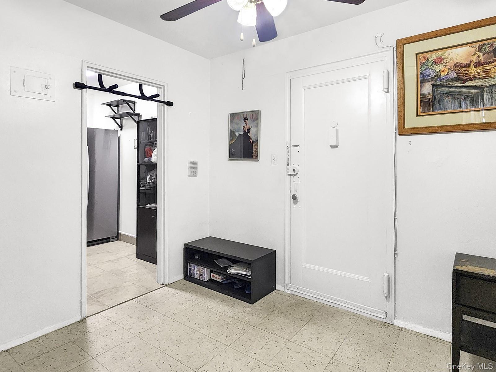 139-15 28th Road, Unit 1F Queens, NY 11354 - Photo 3 of 6 a living room with furniture a ceiling fan and a window