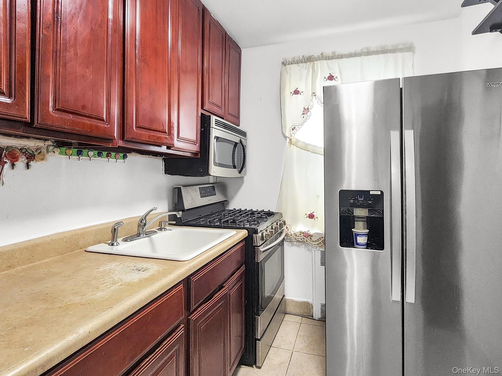 139-15 28th Road, Unit 1F Queens, NY 11354 - Photo 4 of 6 a kitchen with stainless steel appliances granite countertop a refrigerator a sink and dishwasher