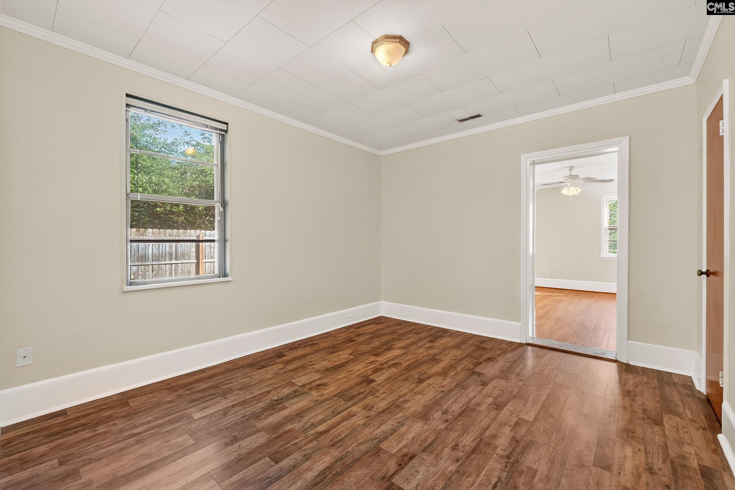 729 Magnolia Street Pelion, SC 29123 - Photo 15 of 32 an empty room with wooden floor and windows