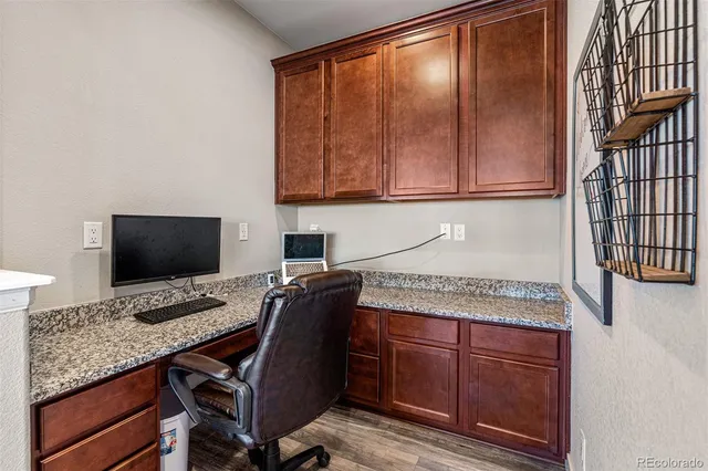 a open kitchen with stainless steel appliances granite countertop a stove a refrigerator a kitchen island a dining table and chairs with wooden floor