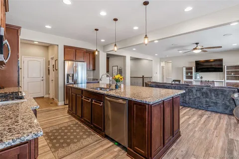 a kitchen with granite countertop a sink a counter top space appliances and cabinets