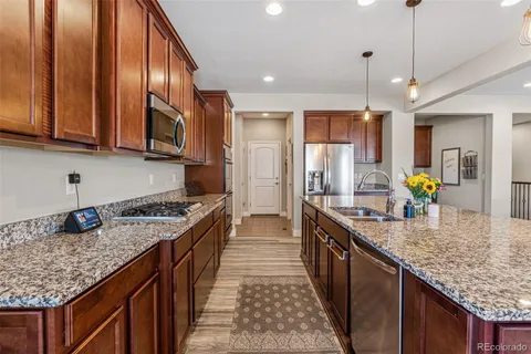 a kitchen with granite countertop a sink a counter top space appliances and cabinets