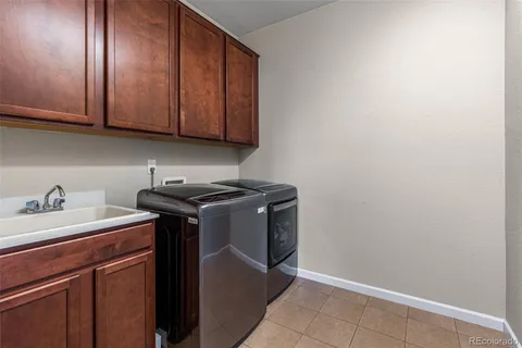a utility room with granite countertop cabinets washer and dryer