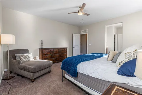 a bedroom with a bed a couch and dresser