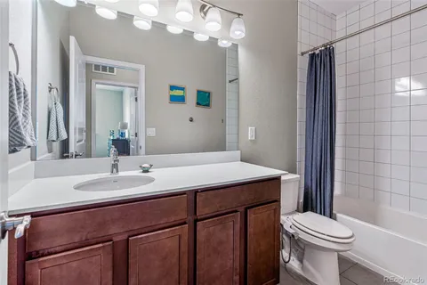 a bathroom with a sink a toilet a mirror and shower