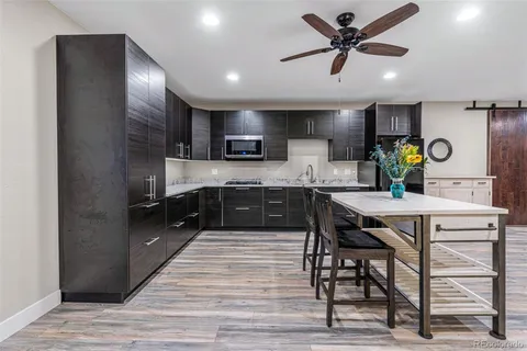 a kitchen with a table chairs refrigerator and microwave