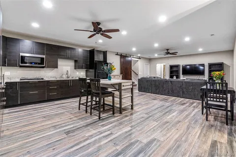 a kitchen with a table chairs refrigerator and microwave