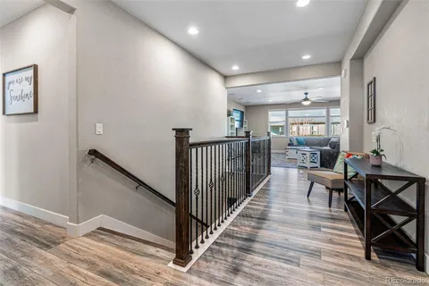a view of a hallway with wooden floor and furniture