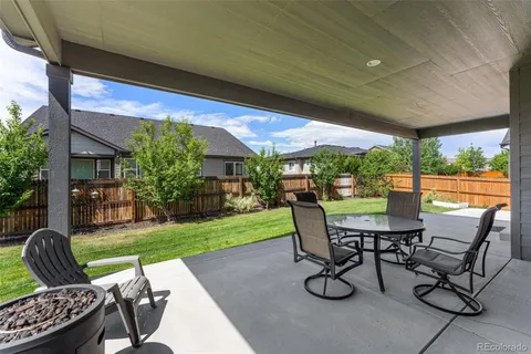 a view of patio with table and chairs under an umbrella