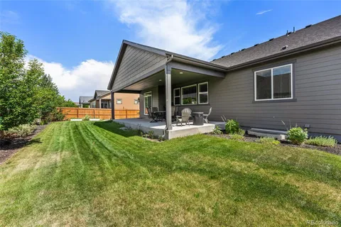 a view of a backyard with table and chairs potted plants with wooden fence