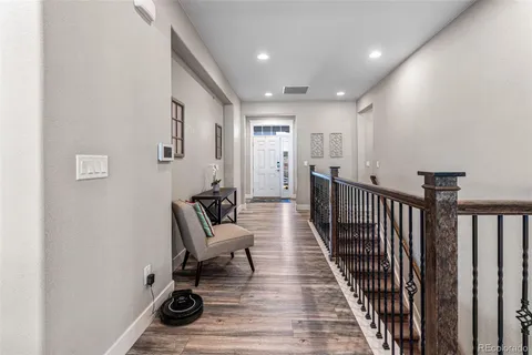 a view of a hallway with wooden floor and furniture