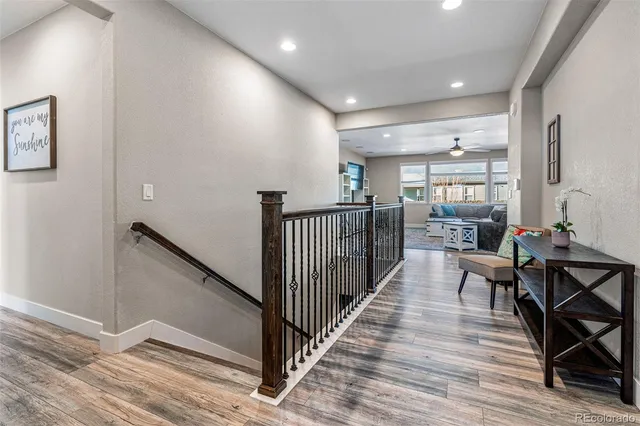a view of a hallway with wooden floor and furniture