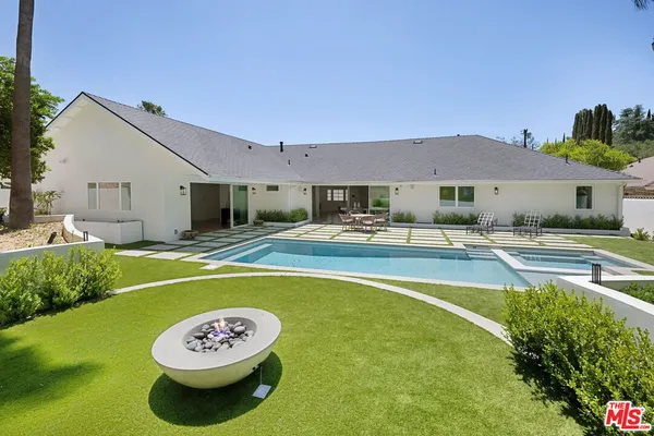 a swimming pool with outdoor seating and yard