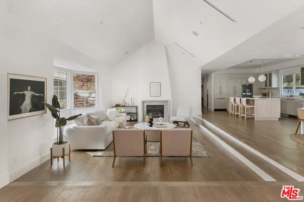 a living room with furniture a large window and a fireplace