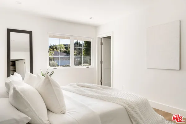 a large bed sitting in a bedroom next to a window