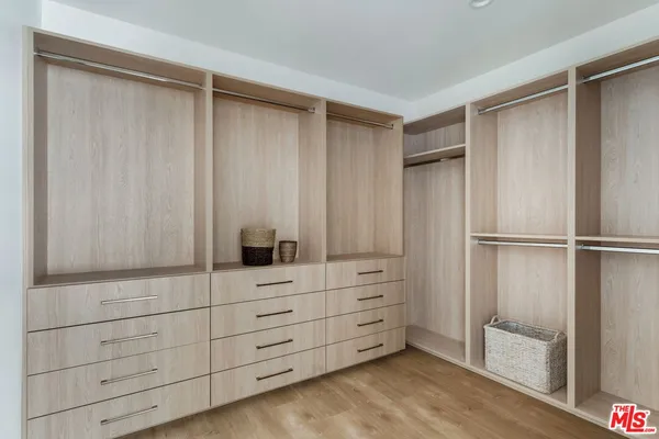 a view of walk in closet with empty racks