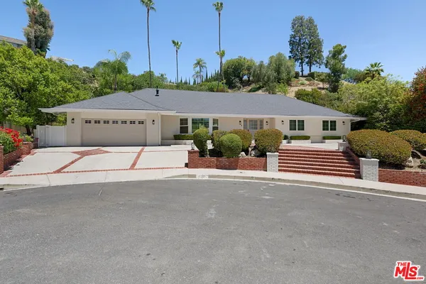 a house with a yard and a car park in front of it