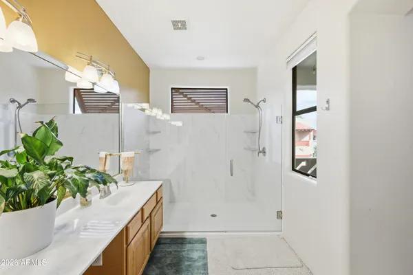 a bathroom with a tub a potted plant on the counter and a window
