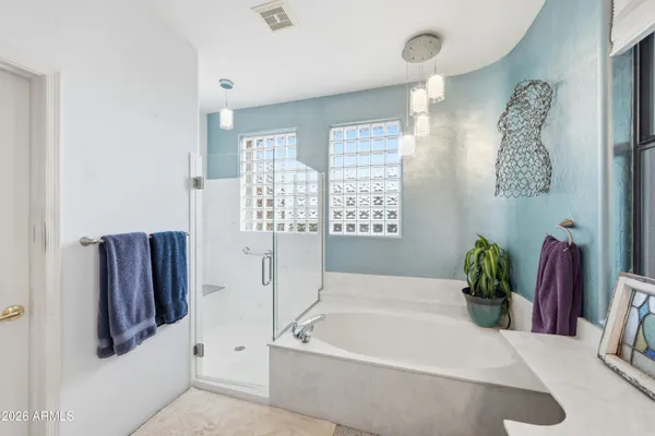 a spacious bathroom with a tub sink and mirror