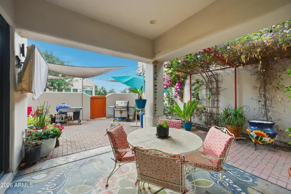 a view of a patio with table and chairs under an umbrella