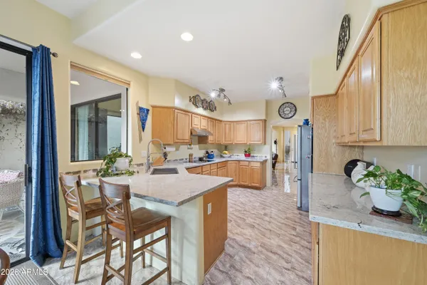 a kitchen with stainless steel appliances granite countertop a refrigerator a stove and a sink with cabinets