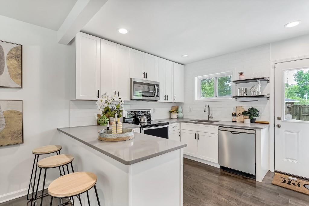a kitchen with white cabinets stove and microwave
