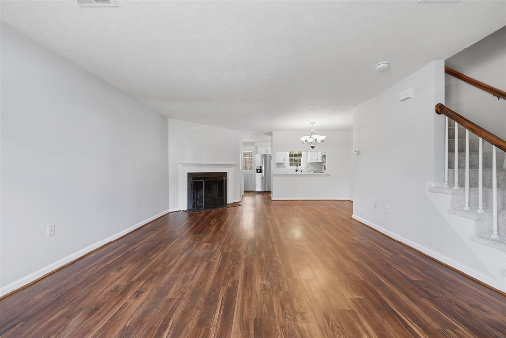 13 Pullard Road, Unit 31 Grafton, MA 01519 - Photo 5 of 34 a view of empty room with wooden floor and fireplace