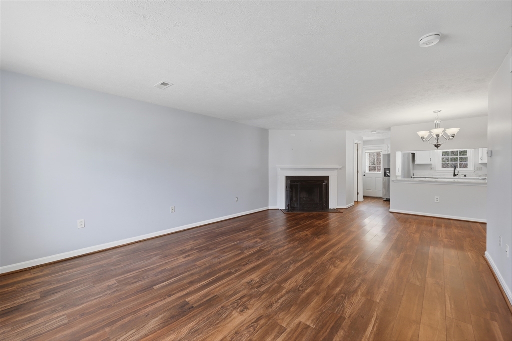13 Pullard Road, Unit 31 Grafton, MA 01519 - Photo 6 of 34 a view of a livingroom with wooden floor and a kitchen