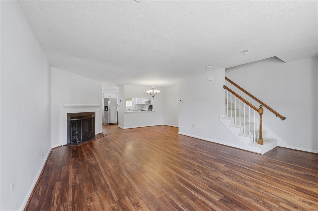 13 Pullard Road, Unit 31 Grafton, MA 01519 - Photo 7 of 34 a view of empty room with wooden floor and fireplace