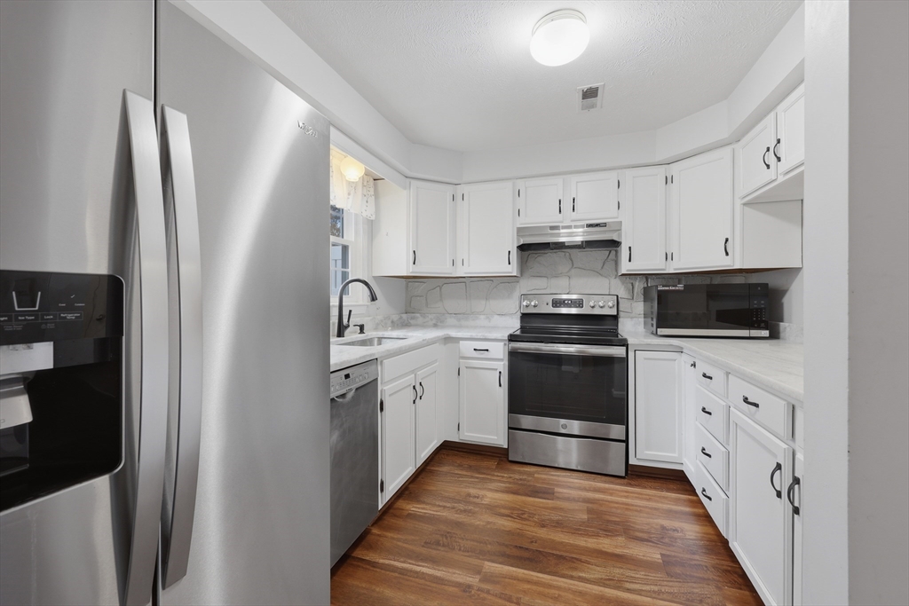13 Pullard Road, Unit 31 Grafton, MA 01519 - Photo 9 of 34 a kitchen with granite countertop a refrigerator stove and white cabinets