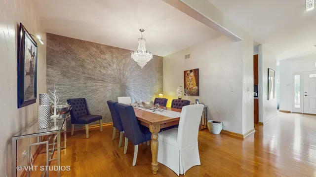 a dining room with furniture a large window and a potted plant