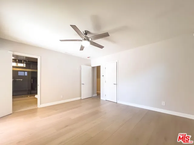 an empty room with closet and windows