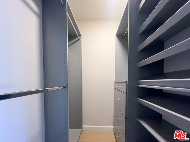 a view of walk in closet with empty racks