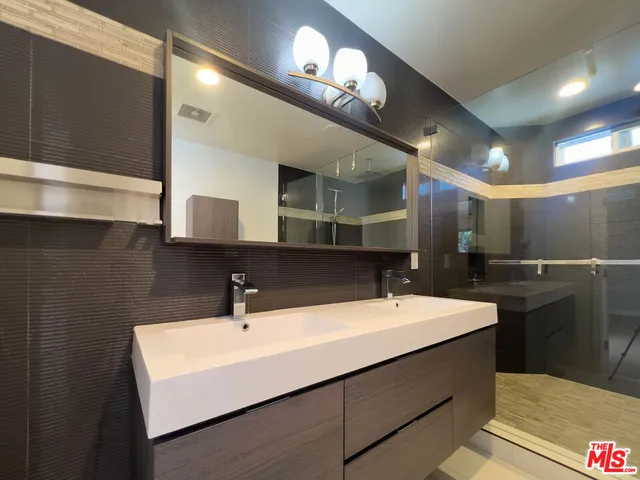 a bathroom with double sink and a mirror