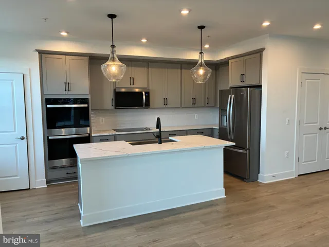 a kitchen with stainless steel appliances granite countertop a refrigerator a sink and a oven