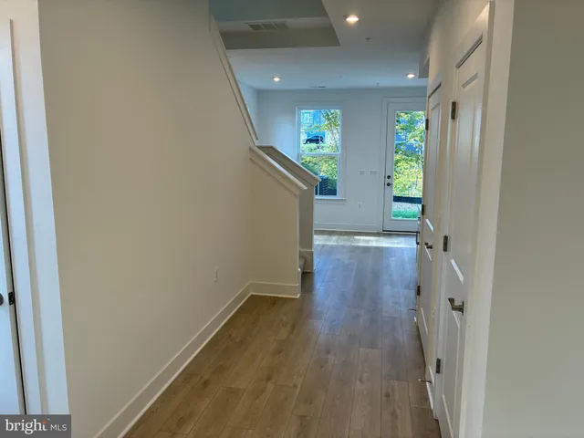 a view of a hallway with wooden floor and staircase