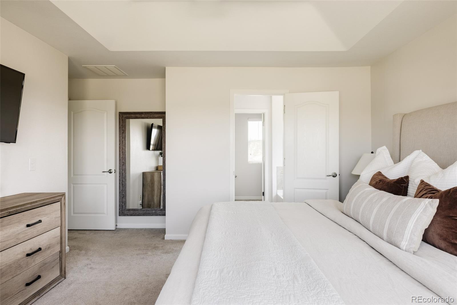 2899 Trinity Loop Broomfield, CO 80023 - Photo 16 of 33 a spacious bedroom with a bed and a flat screen tv